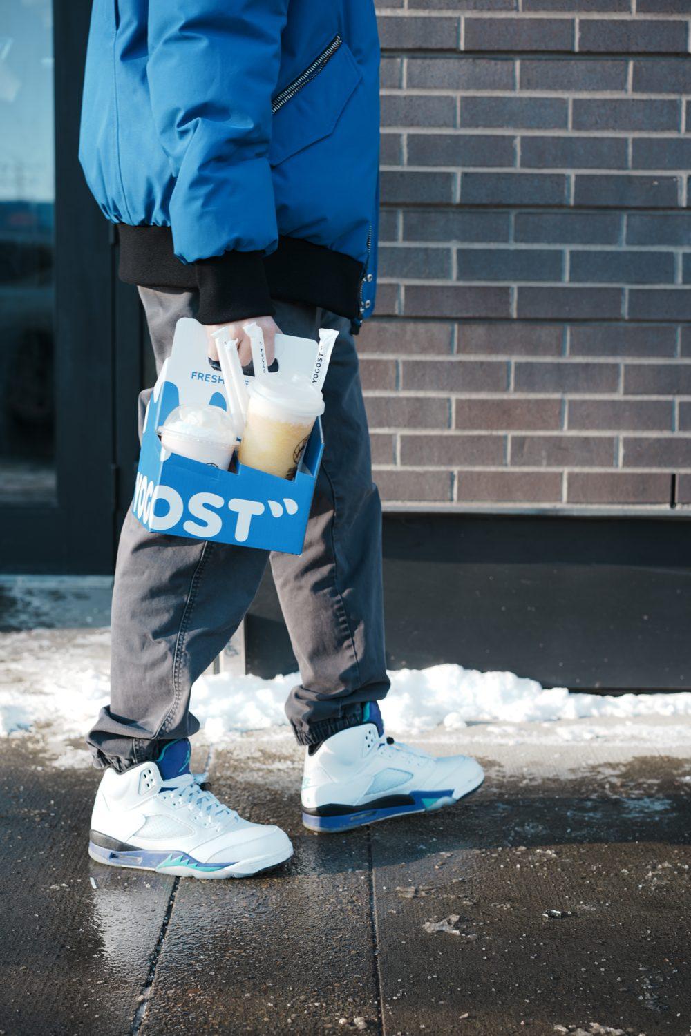 A customer carrying Yogost drinks beside the snow