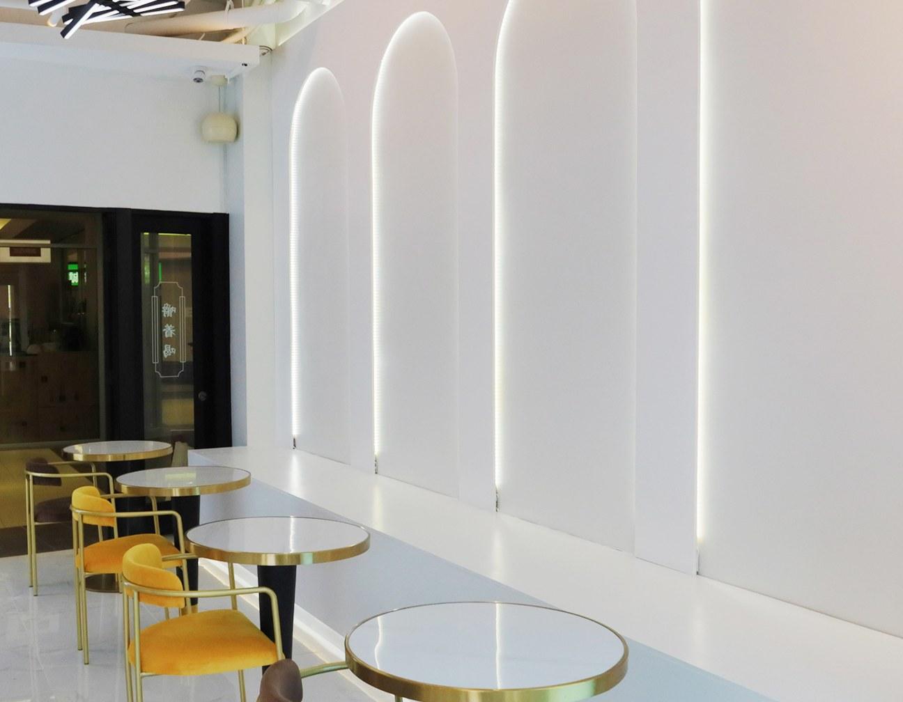 Lit arches and gold-rimmed tables inside the Lansdowne Yogost